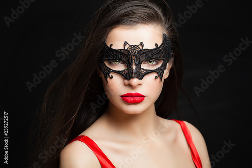 Perfect sexy woman in carnival mask on black background with abstract night glitter bokeh