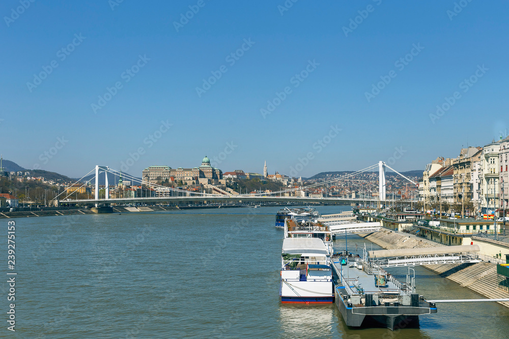 view of tourist ships on the Danube on the background of the bridge and blue sky