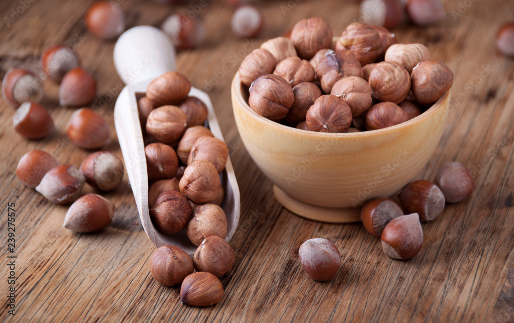 Hazelnuts in a wooden spoon and wooden bowl Hazelnuts in a wooden spoon and wooden bowl