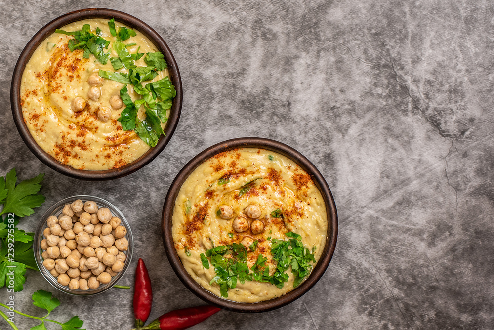 Classic hummus in bowls on a grey background. With copy space. Top view Classic hummus in bowls on a grey background. With copy space. Top view