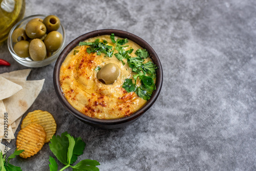 Classic hummus in bowls on a grey background. With copy space