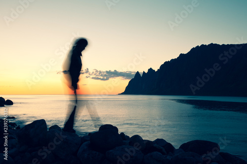 Silhouette einer jungen Frau vor einer grandiosen Kulisse am Meer