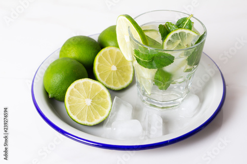 drink, water, mojito lime and mint with ice on a tray on a white background.