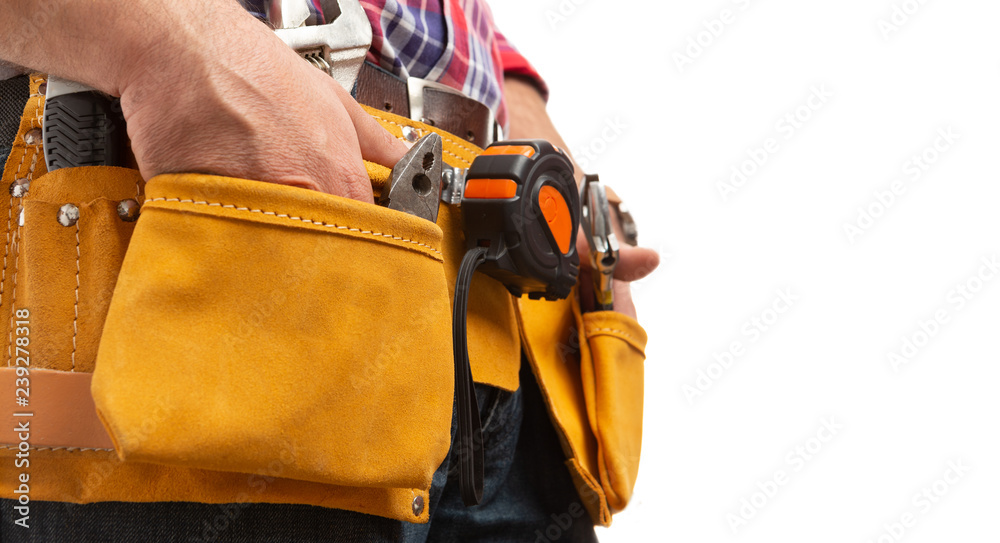 Lateral view of constructor holding hands inside tool belt pockets. Lateral view of constructor holding hands inside tool belt pockets.