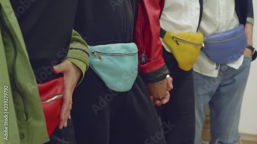 Four people with fanny packs on hips during photo session.