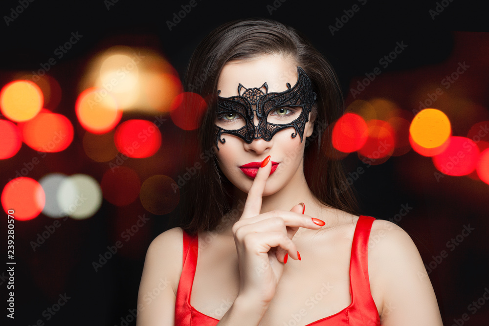 Pretty woman brunette model in black carnival mask on abstract night glitter bokeh background