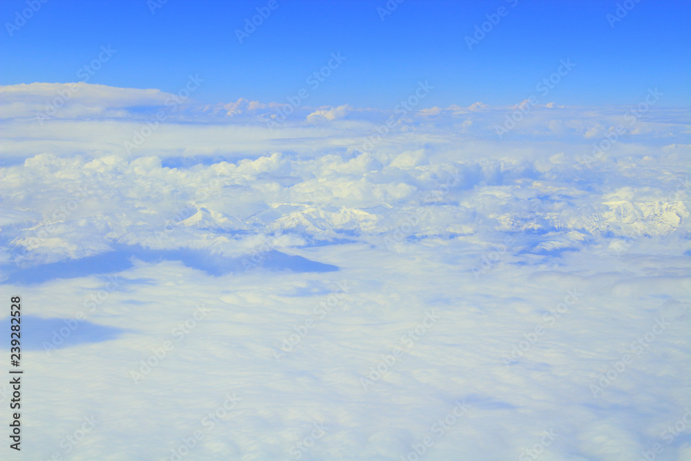 Beautiful layered cumulus clouds and mountains. View from the plane. Background. Landscape.