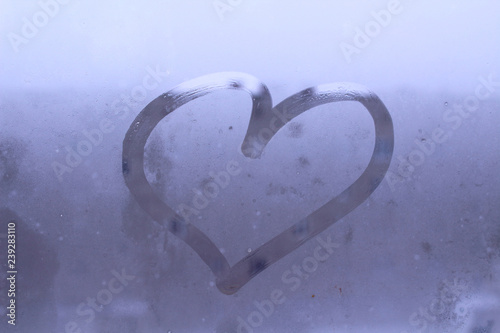 Heart drawn on the glass with your finger. Close-up. Background. Texture.