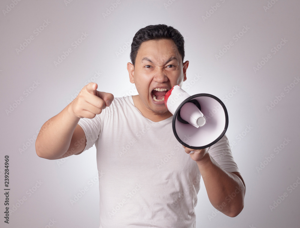 Young Man Shouting with Megaphone, Angry Expression Young Man Shouting with Megaphone, Angry Expression