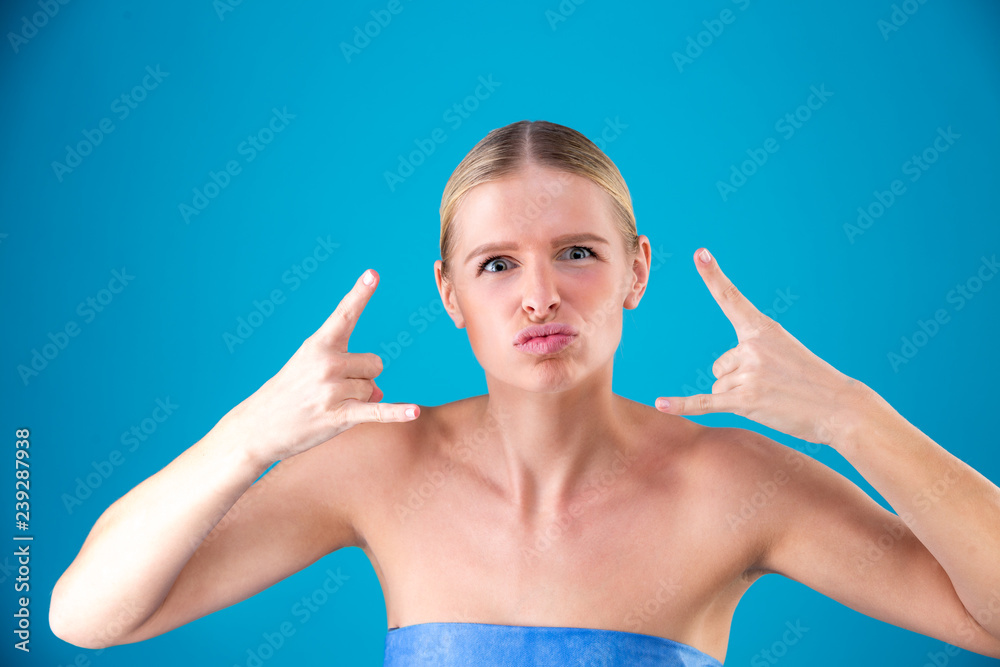 Close up portrait of Beautiful model girl on blue background show tongue out and shows a gesture with his hands Rock n Roll. The concept of body language Close up portrait of Beautiful model girl on blue background show tongue out and shows a gesture with his hands Rock n Roll. The concept of body language