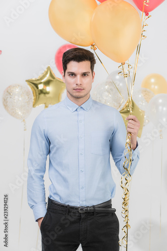 Handsome man hodling colorful balloons. photo