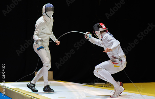 Two man fencing athletes fight