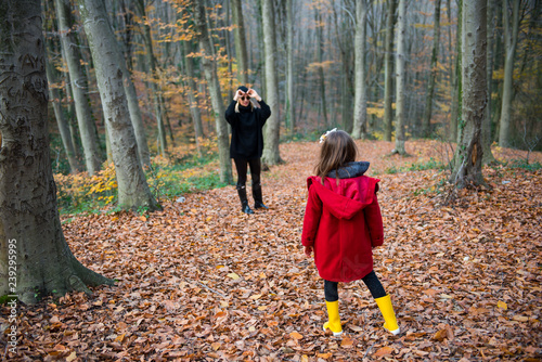 Mother and daughter walking on the forest at autumn