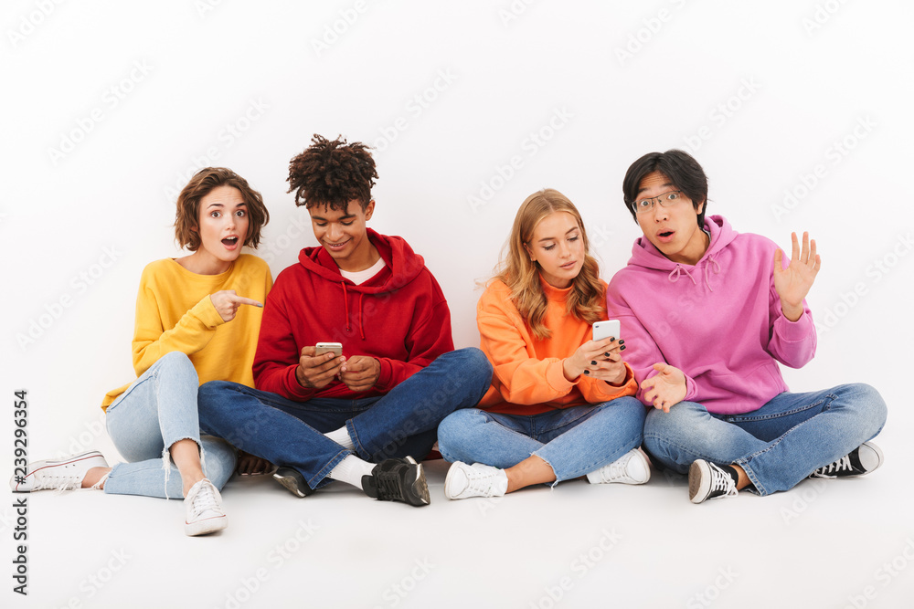 Group of cheerful multiracial friends sitting isolated Group of cheerful multiracial friends sitting isolated