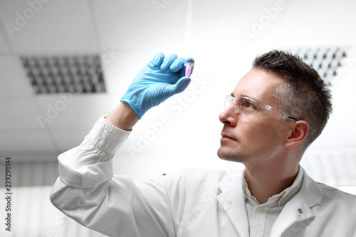 Badania i diagnostyka laboratoryjna. Laborant ogląda preparat w próbówce.
