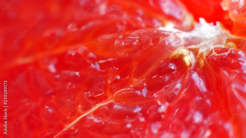 Red juicy pulp of grapefruit. Slice of cut grapefruit from which juice flows. Macro shooting of pink grapefruit pulp. 