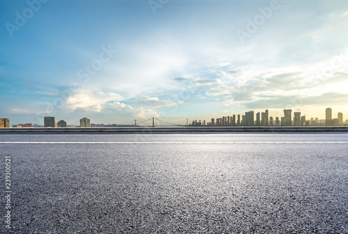 empty asphalt road with city skyline