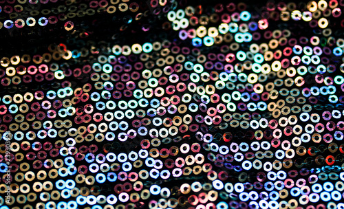textured background of shiny round sequins sewn on fabric for a trendy evening dress