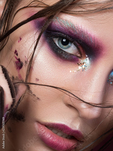 Beauty portrait of a young girl with fashion creative make-up. Colorful smoky eyes. Studio shot. Sensuality, passion, trendy youth makeup concept.