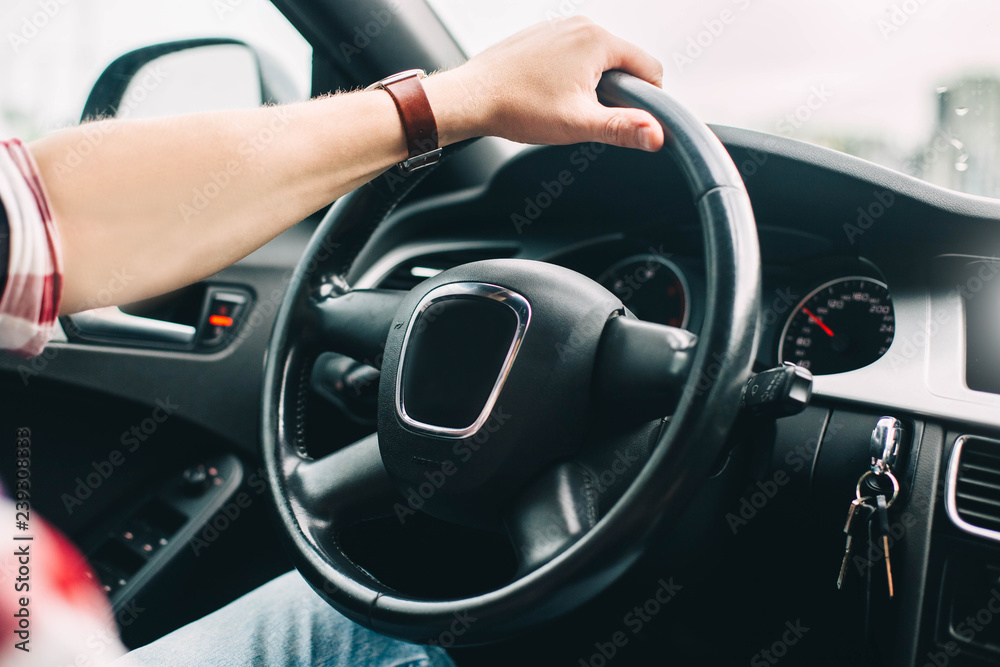 trip on a modern car. The hands of the driver on the steering wheel.