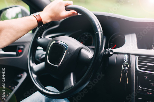 trip on a modern car. The hands of the driver on the steering wheel. © velimir
