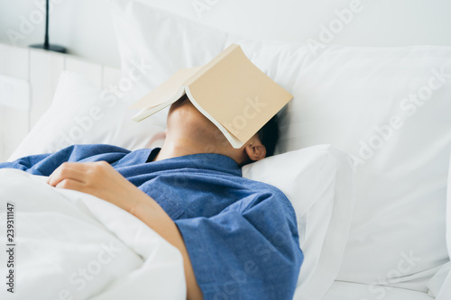 Asian handsome man Read books while sleeping. Man book cover Drowsiness causes sleep.The concept of adequate sleep. Good sleep