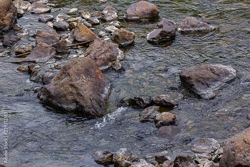 water of stream flowing around boulders and stones