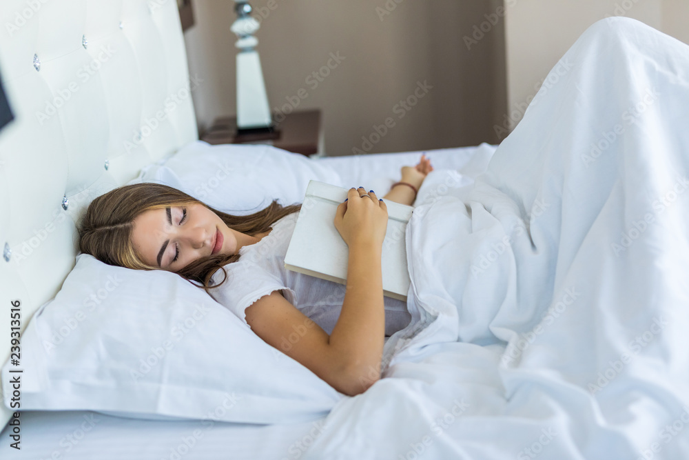 Beautiful young woman falling asleep while reading a book Beautiful young woman falling asleep while reading a book