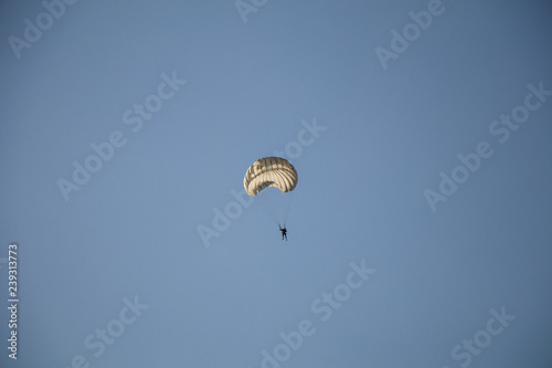  Jump of paratrooper with white parachute, Military parachute jumper in the sky.