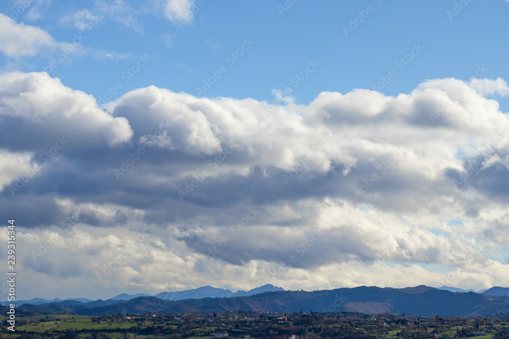 Mountain range in clear weather in contrasting rain clouds before the rain Mountain range in clear weather in contrasting rain clouds before the rain