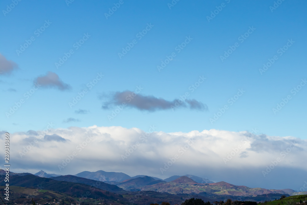 Mountain range in clear weather in contrasting rain clouds before the rain Mountain range in clear weather in contrasting rain clouds before the rain