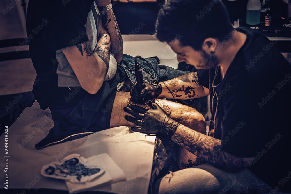 Tatuatore che Tatua coscia - obrazy, fototapety, plakaty 