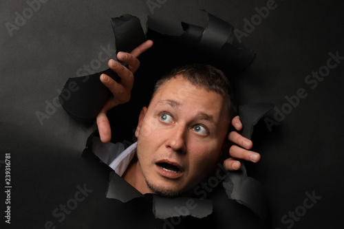 Frightened man tearing dark...