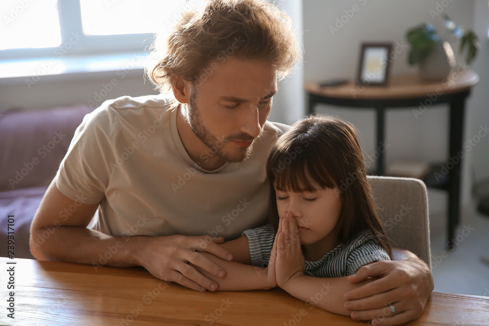 Father with daughter praying at home