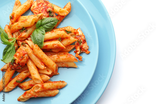Plates with tasty penne pasta on white background