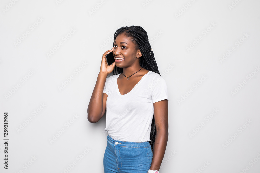 Portrait of cute woman with trendy hairstyle wearing basic t-shirt talking on mobile phone isolated over white background Portrait of cute woman with trendy hairstyle wearing basic t-shirt talking on mobile phone isolated over white background