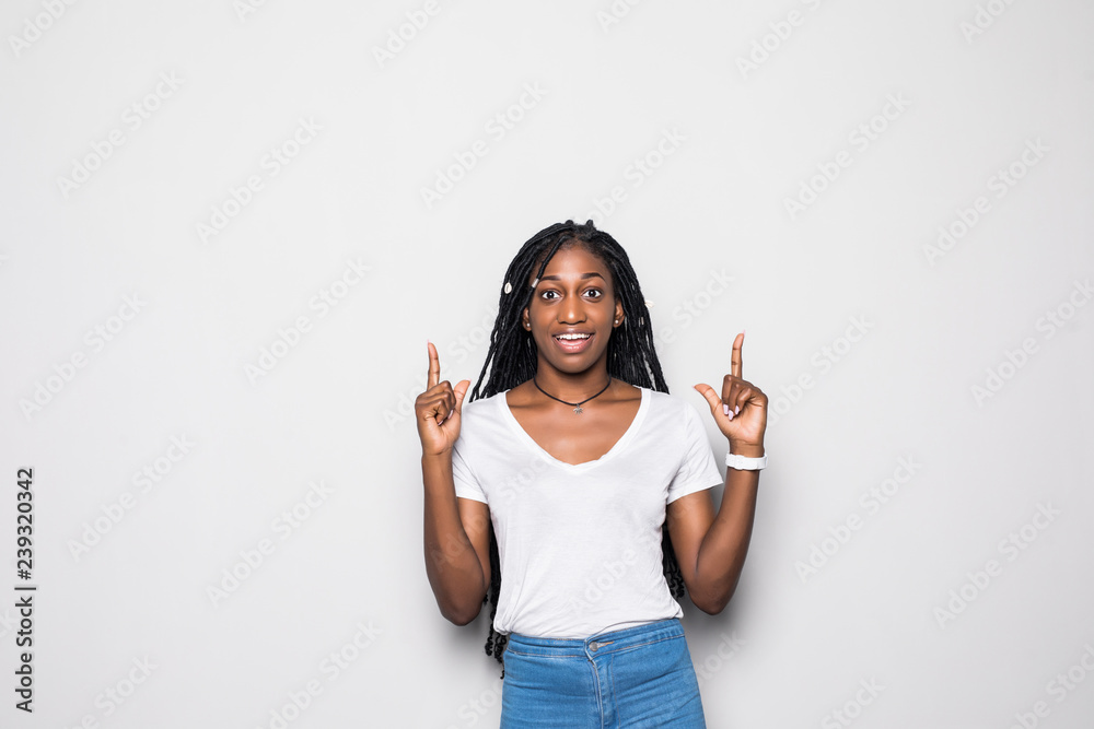 Portrait of a happy woman pointing up and smiling against white background Portrait of a happy woman pointing up and smiling against white background