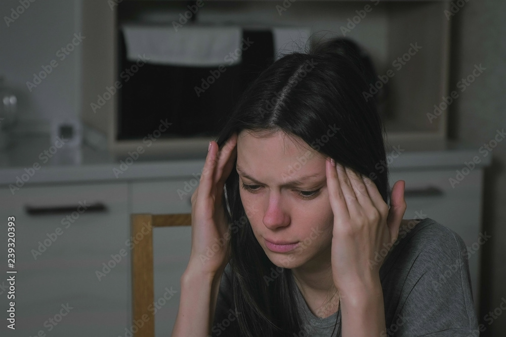 Woman with headache in the kitchen at night. Insomnia and depression. Woman with headache in the kitchen at night. Insomnia and depression.
