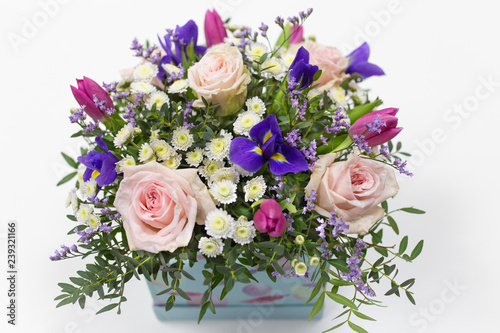 Delicate bouquet of flowers (roses, tulips, irises) in a box