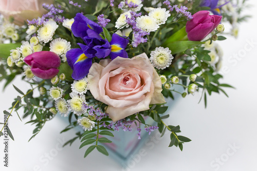 Delicate bouquet of flowers (roses, tulips, irises) in a box