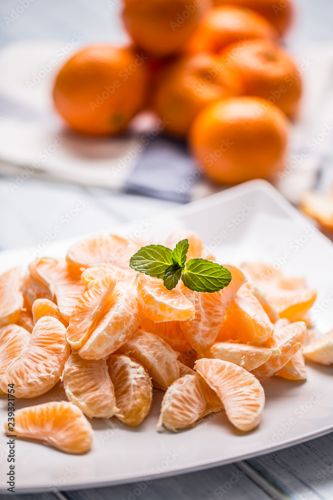 Fresh pieces of tangerines mandarin on the plate or in a bowl Fresh pieces of tangerines mandarin on the plate or in a bowl