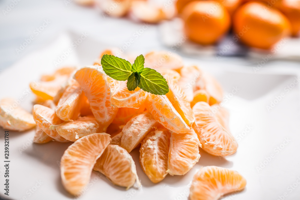 Fresh pieces of tangerines mandarin on the plate or in a bowl Fresh pieces of tangerines mandarin on the plate or in a bowl