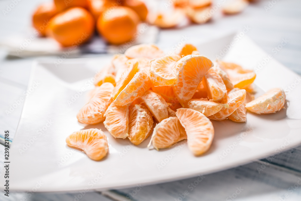 Fresh pieces of tangerines mandarin on the plate or in a bowl Fresh pieces of tangerines mandarin on the plate or in a bowl