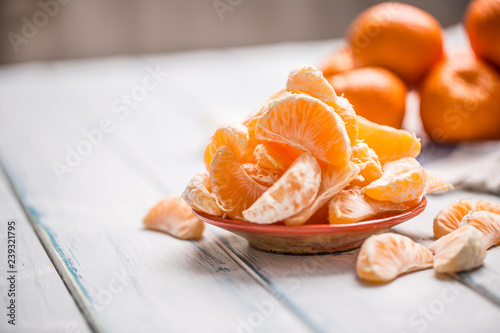Fresh pieces of tangerines mandarin on the plate or in a bowl