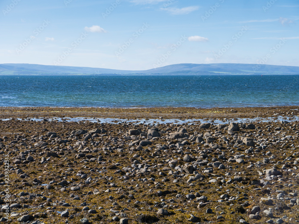 pebble beach and panorama of ocean and mountains in ireland pebble beach and panorama of ocean and mountains in ireland