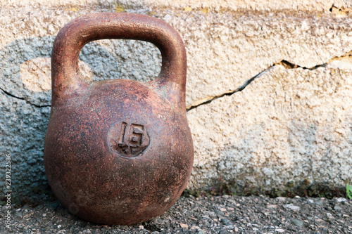 Old cast-iron sports weight on the wall background. Inventory for power sport of bodybuilding.