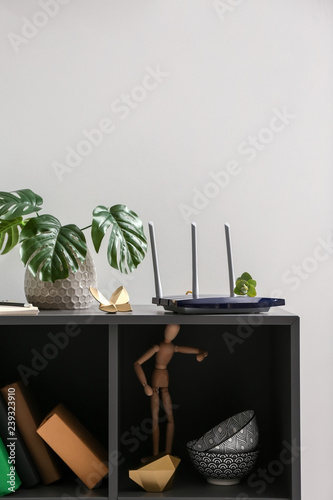 Modern wi-fi router on dark shelf photo