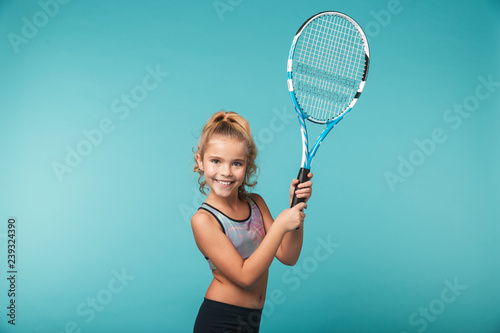Cheerful young sports girl playing tennis