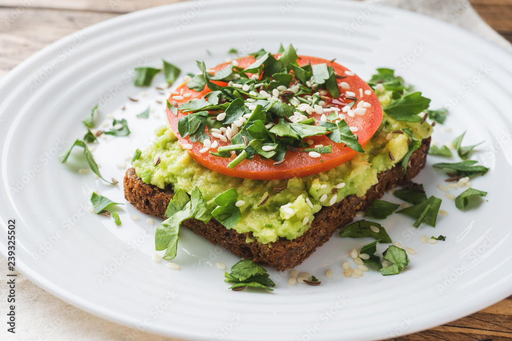 Avocado toast. Healthy toast with avocado mash and tomatoes on a plate.
