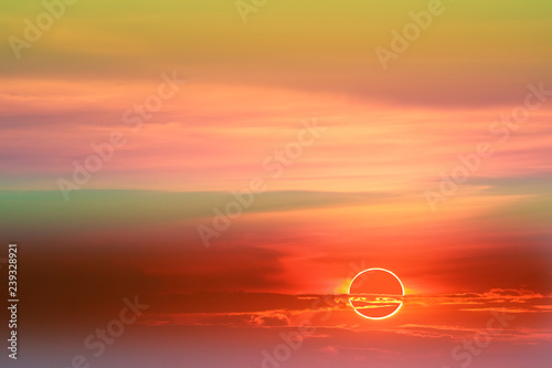 annular eclipse over colorful soft cloud sunset sky photo